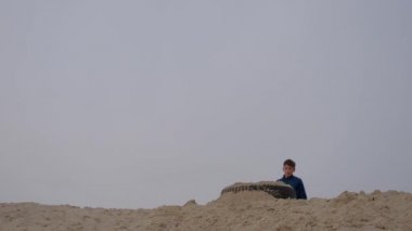 Çocuklar ve gençler beyaz kumda eğlenirler. Parkour