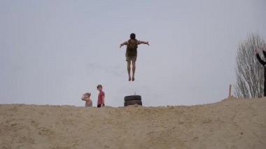Gomel, Beyaz Rusya - 21 Nisan 2019: Çocuklar ve gençler beyaz kumda eğleniyor. Parkour