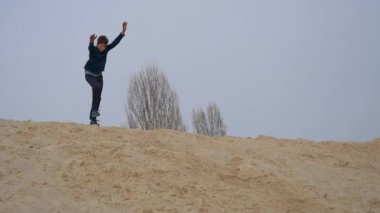 Çocuklar ve gençler beyaz kumda eğlenirler. Parkour