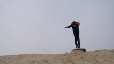 Çocuklar ve gençler beyaz kumda eğlenirler. Parkour