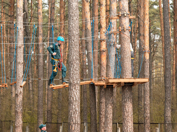 ГОМЕЛЬ, БЕЛАРУС - 21 апреля 2019 года: Лицей МЧС. Веревочный городок полоса препятствий на деревьях для подготовки курсантов
