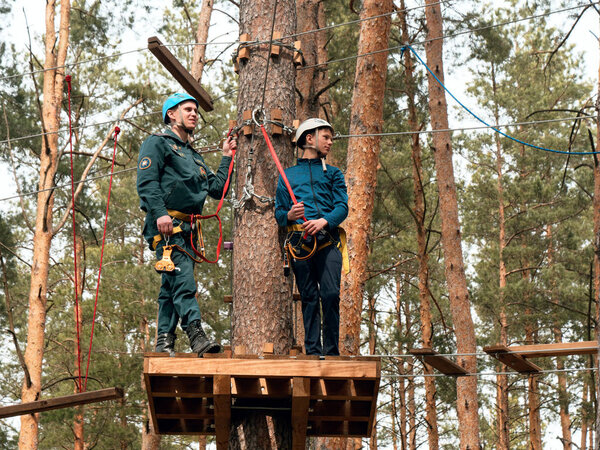 ГОМЕЛЬ, БЕЛАРУС - 21 апреля 2019 года: Лицей МЧС. Веревочный городок полоса препятствий на деревьях для подготовки курсантов
