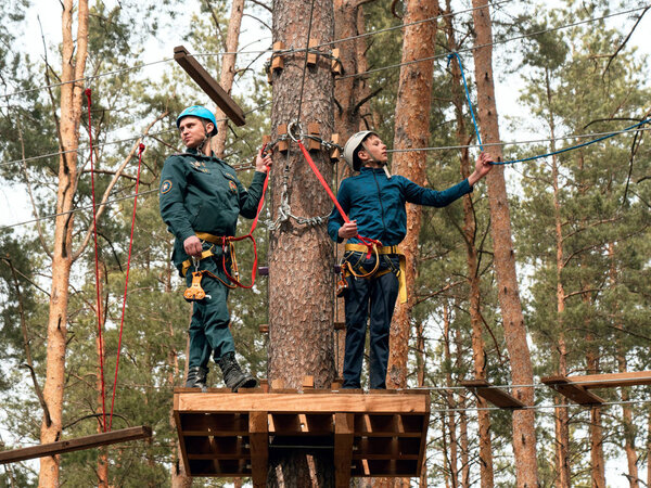 ГОМЕЛЬ, БЕЛАРУС - 21 апреля 2019 года: Лицей МЧС. Веревочный городок полоса препятствий на деревьях для подготовки курсантов
