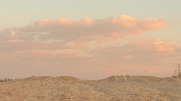 Wolken bij zonsondergang boven de zand woestijn — Stockvideo