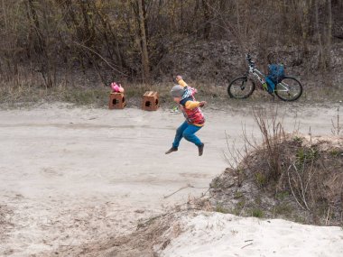 Çocuklar ve gençler beyaz kumda eğlenirler. Parkour