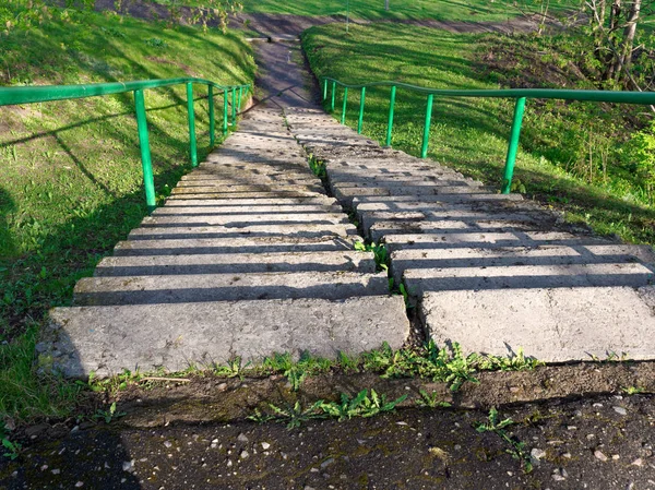 Betonové schodiště na příkrém svahu zelené trávy — Stock fotografie