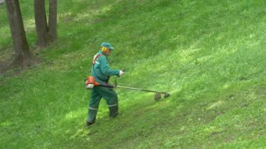 Gomel, Beyaz Rusya - 15 Mayıs 2019: Saray ve park topluluğu Paskevichi. Bir adam çim biçme makinesi ni biçer..