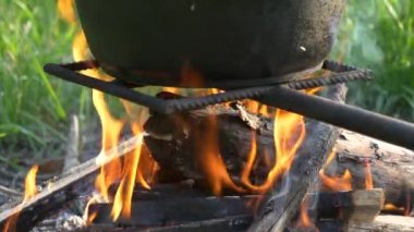 yeşil bir arka plan üzerinde ateşte pot.