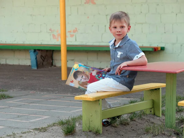 Niño de 6 años sentado en un banco — Foto de Stock