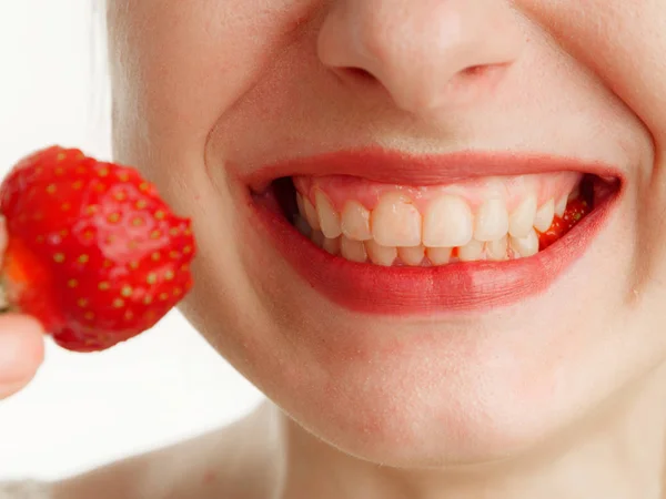 Boca femenina con dientes fresas sobre un fondo blanco — Foto de Stock