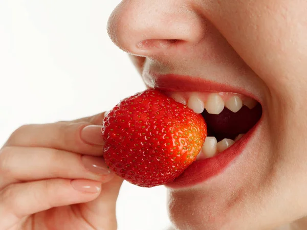 Boca femenina con dientes fresas sobre un fondo blanco — Foto de Stock