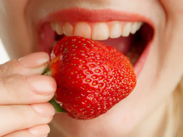 Boca femenina con dientes fresas sobre un fondo blanco — Foto de Stock