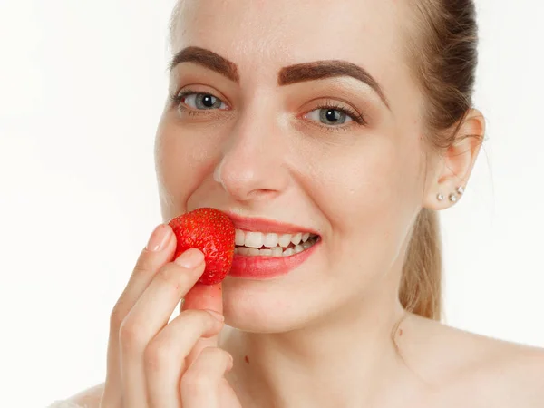 Hermosa chica hace maquillaje fresa bayas en un blanco backgr — Foto de Stock