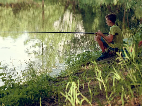 Teenie-Kind fängt Angelrute am Teich. — Stockfoto