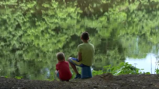 十几岁的孩子在池塘上捉到一根钓鱼竿 — 图库视频影像