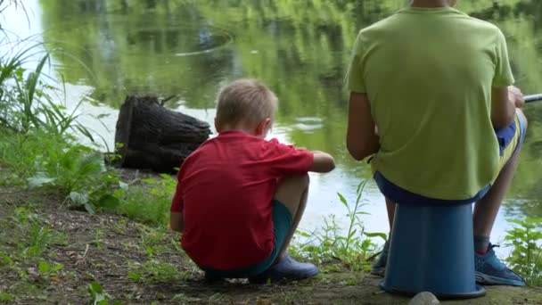 十几岁的孩子在池塘上捉到一根钓鱼竿 — 图库视频影像