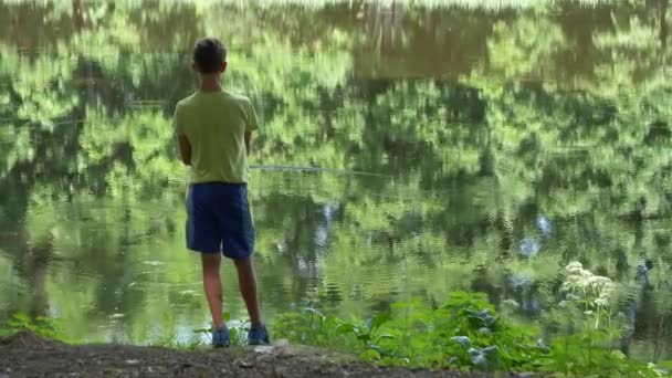 Έφηβος Παιδί Πιάνει Ένα Καλάμι Ψαρέματος Στη Λιμνούλα — Αρχείο Βίντεο