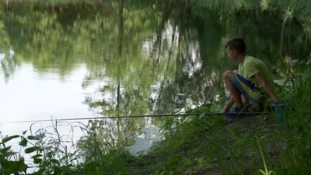 Έφηβος Παιδί Πιάνει Ένα Καλάμι Ψαρέματος Στη Λιμνούλα — Αρχείο Βίντεο