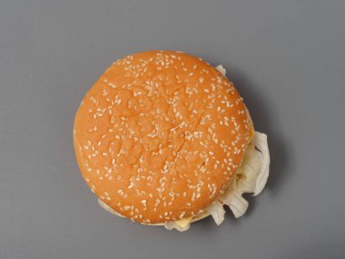 gri arka plan üzerinde pirpirit peynir domates lahana ile büyük burger