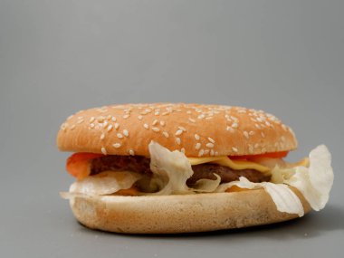 gri arka plan üzerinde pirpirit peynir domates lahana ile büyük burger