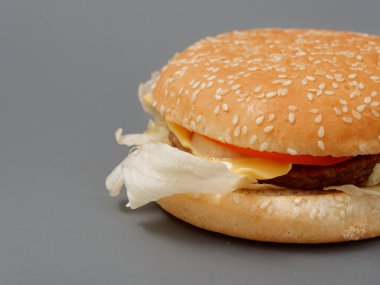 gri arka plan üzerinde pirpirit peynir domates lahana ile büyük burger
