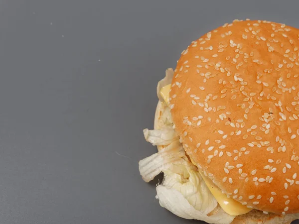 Большой гамбургер с котлетами и помидорами на сером фоне — стоковое фото