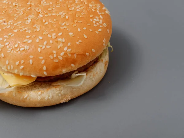 Большой гамбургер с котлетами и помидорами на сером фоне — стоковое фото