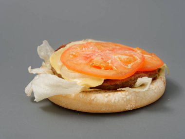 gri arka plan üzerinde pirpirit peynir domates lahana ile büyük burger