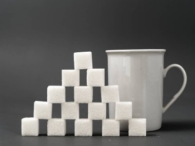 gri bir arka plan üzerinde rafine şeker yumru beyaz ve beyaz fincan