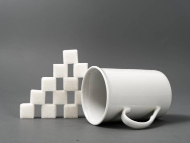 gri bir arka plan üzerinde rafine şeker yumru beyaz ve beyaz fincan