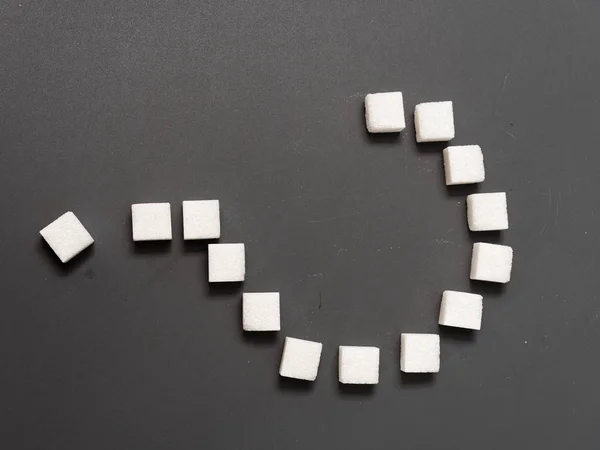 Witte suiker en vraagteken op een grijze achtergrond — Stockfoto