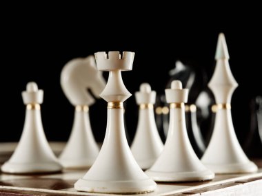 siyah bir arka plan üzerinde tahta üzerinde satranç taşları