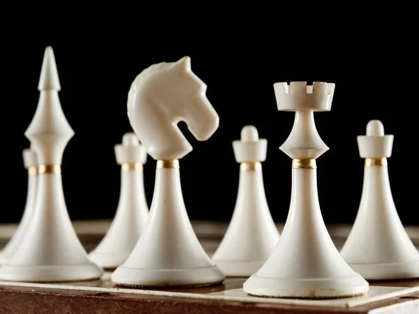 Pièces d'échecs sur l'échiquier sur fond noir — Photo
