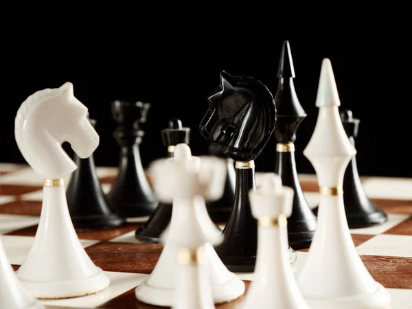 Pièces d'échecs sur l'échiquier sur fond noir — Photo