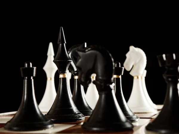 Chess pieces on the board on a black background — Stock Photo, Image