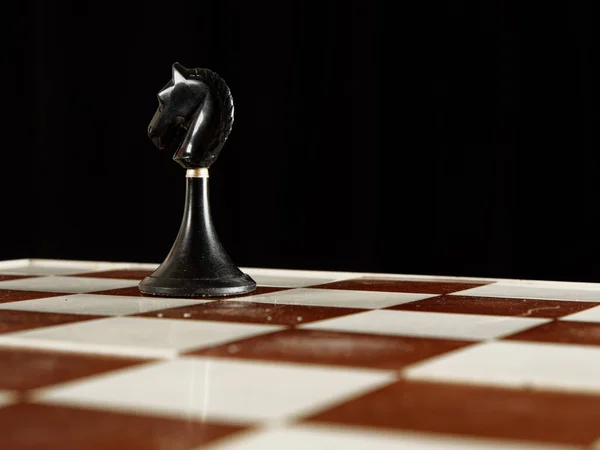 Pièces d'échecs sur l'échiquier sur fond noir — Photo