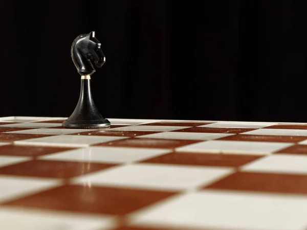 Pièces d'échecs sur l'échiquier sur fond noir — Photo