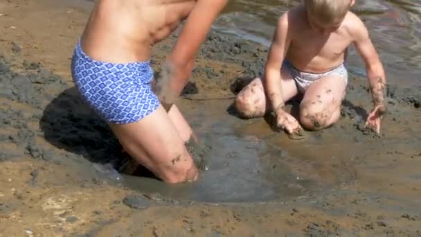少年は砂浜で砂遊び — ストック動画