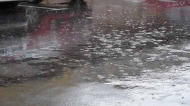 bir su birikintisi kabarcıkları ile düşen yağmur damlaları
