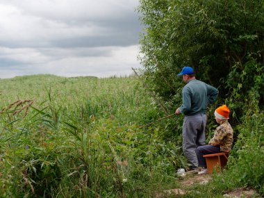 bir balıkçı çubuğu ile baba ve oğul balıkçılık