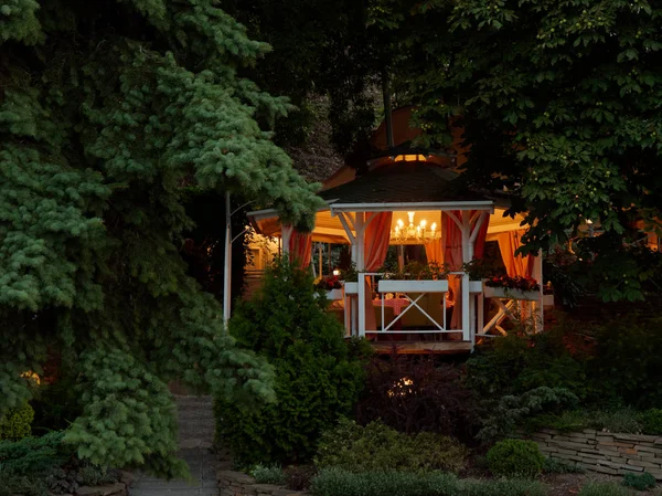 GOMEL, BELARUS Accogliente gazebo con illuminazione nelle boscaglie verdi la sera — Foto Stock