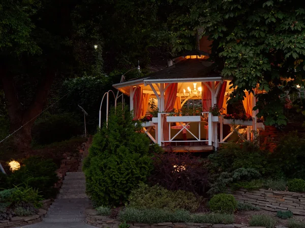 GOMEL, BELARUS Cozy gazebo with lighting in the green thickets in the evening 