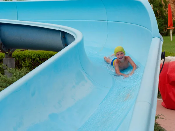 Garçon promenades toboggan aquatique au parc aquatique — Photo