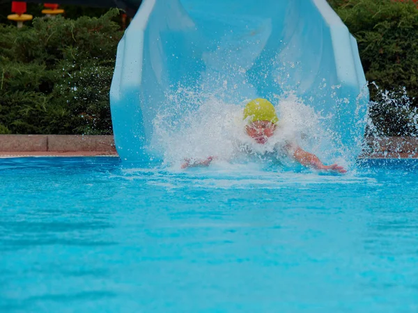 Garçon promenades toboggan aquatique au parc aquatique — Photo