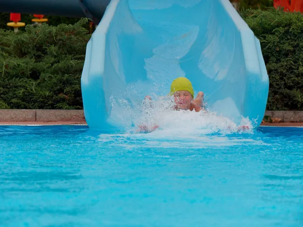 Garçon promenades toboggan aquatique au parc aquatique — Photo