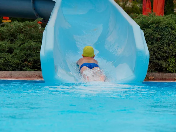 Garçon promenades toboggan aquatique au parc aquatique — Photo