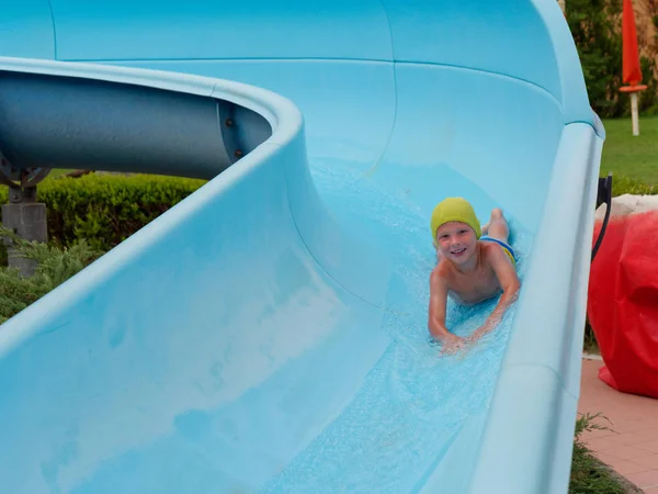 Boy rides water slide rides at the water park — Stock Photo, Image