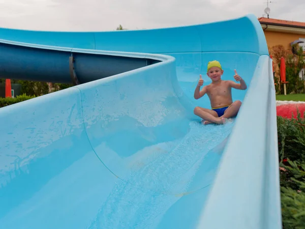 Boy rides water slide rides at the water park — Stock Photo, Image