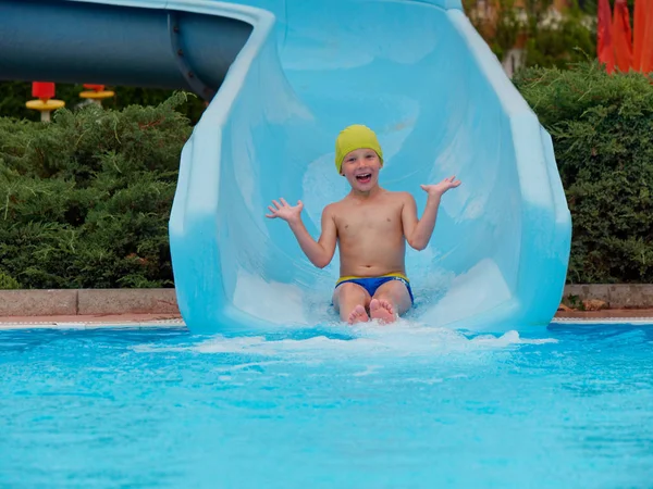 Garçon promenades toboggan aquatique au parc aquatique — Photo