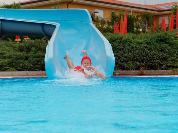 Garçon promenades toboggan aquatique au parc aquatique — Photo